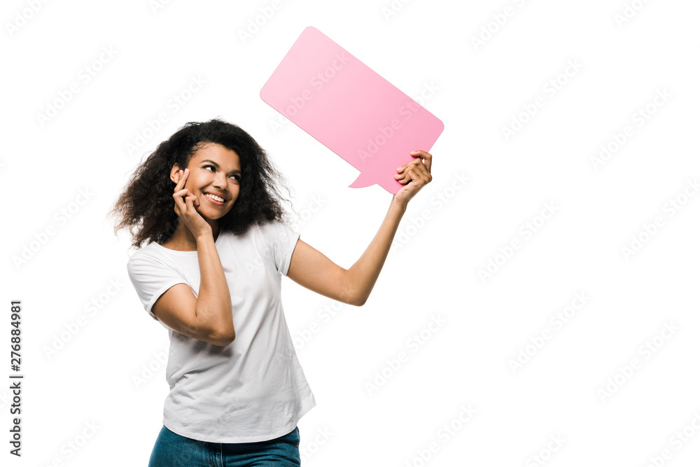 cheerful african american girl looking at pink speech bubble isolated on white cheerful african american girl looking at pink speech bubble isolated on white