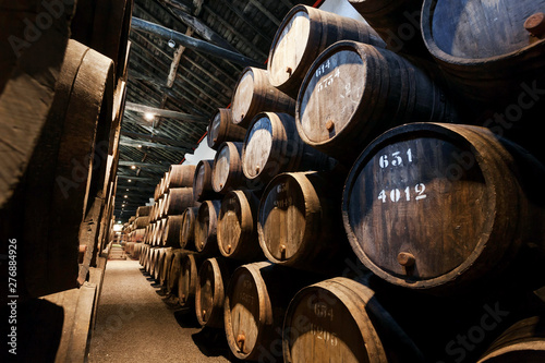 Dark wine cellar with numbered wooden barrels for traditional winemaking Fototapeta
