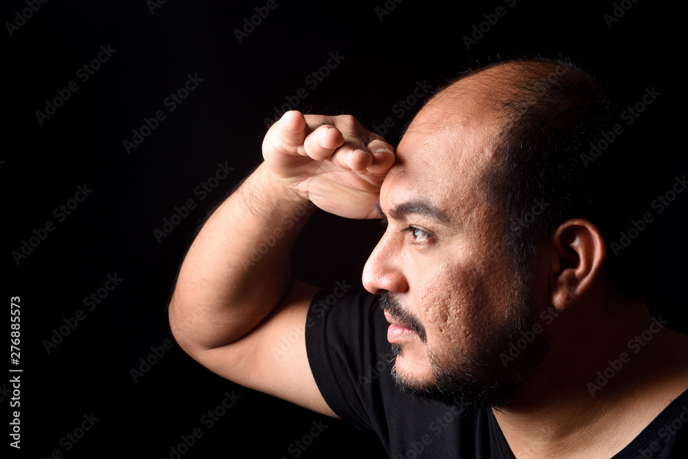 latin american man with hand in front looking away on black background latin american man with hand in front looking away on black background