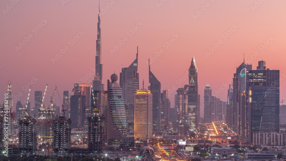 Naklejka premium Dubai skyline after sunset with beautiful city center lights and Sheikh Zayed road traffic timelapse, Dubai, United Arab Emirates