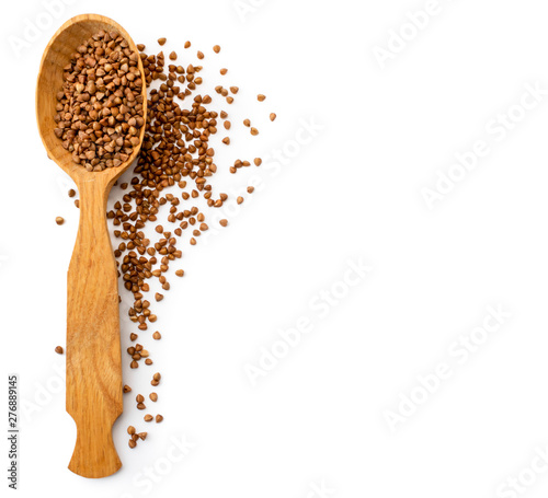 Wooden spoon with a sprinkled buckwheat on a white. The view of the top.