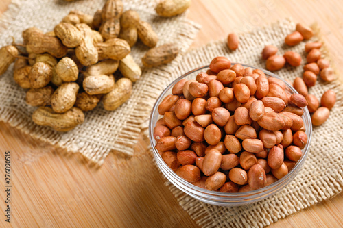 peanuts in bowl on the wooden background.