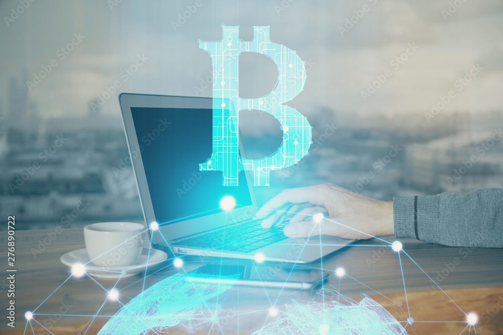 Obraz premium Crypto currency theme hologram with businessman working on computer on background. Concept of blockchain. Double exposure.