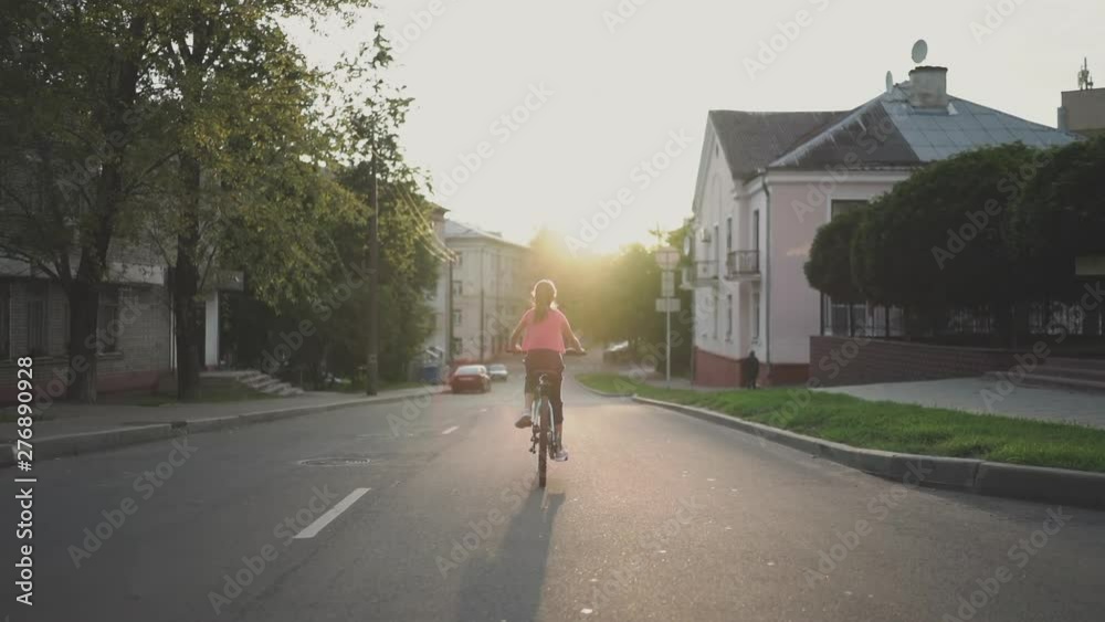 Child Girl Riding Bike at Sunset in Slow Motion