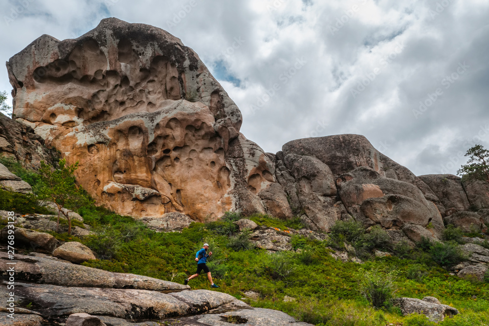 Athlete runner running on a mountain trail Athlete runner running on a mountain trail