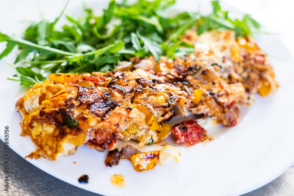 Omelete with arugula on white plate