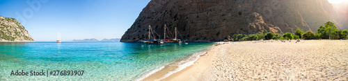 Photo Sailing ships moored in a secluded bay with turquoise water and empty beach at s