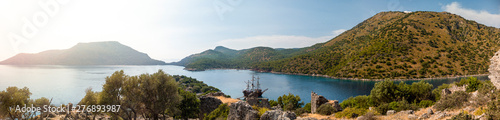 Photo Pirate ship moored in a secluded bay with turquoise water at sunset, Oludeniz, T