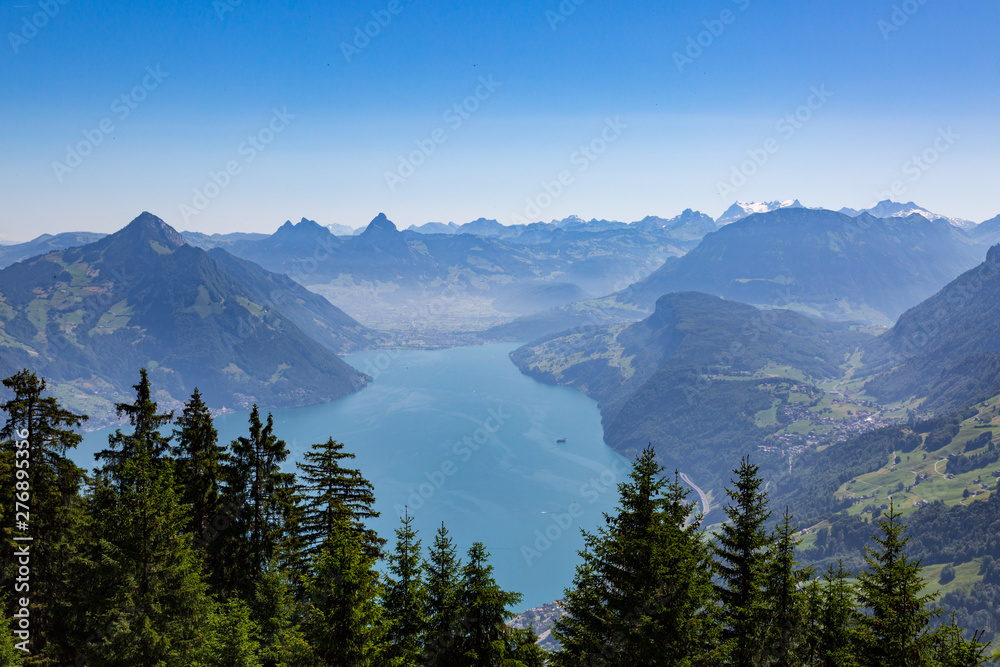 lake Lucerne with blue sky, Swiss alps, Mythen mountains, forest