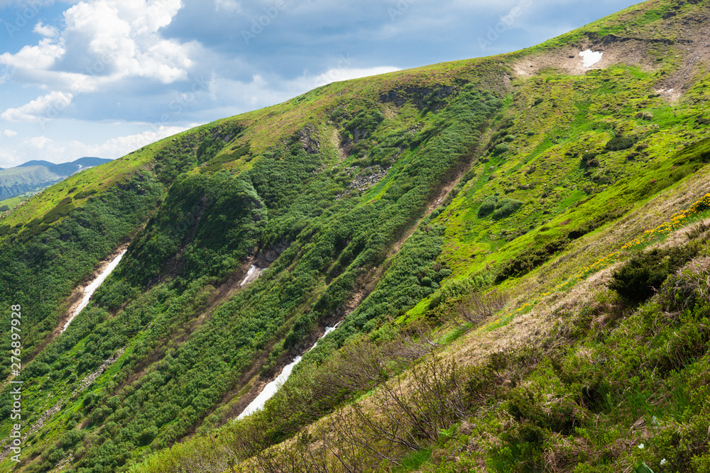 Beautiful view on the mountain slope of Chornohora mountains with a little snow and forests from Mount Hoverla. It is the highest mountain of the Ukrainian Carpathian Mountains Beautiful view on the mountain slope of Chornohora mountains with a little snow and forests from Mount Hoverla. It is the highest mountain of the Ukrainian Carpathian Mountains