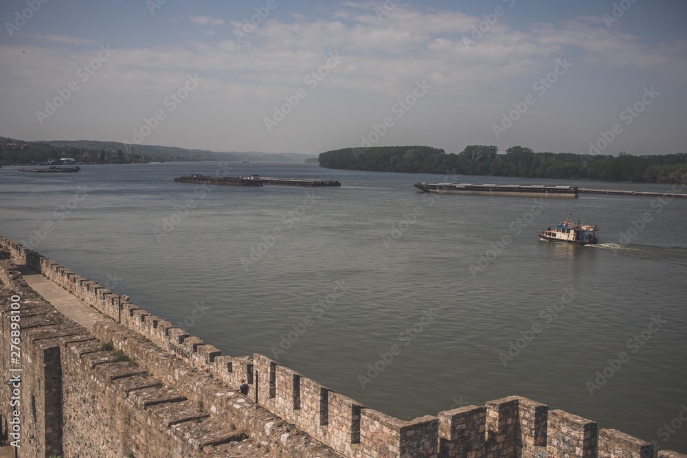 Medieval fortress in Smederevo, Serbia, on coast of Danube river with tankers in background