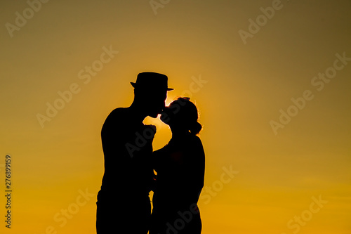 Couple on the beach with a beautiful sunset in background