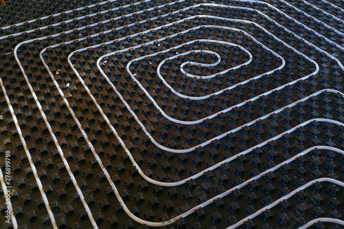 Fotografía Black underfloor heating surface with heating pipes