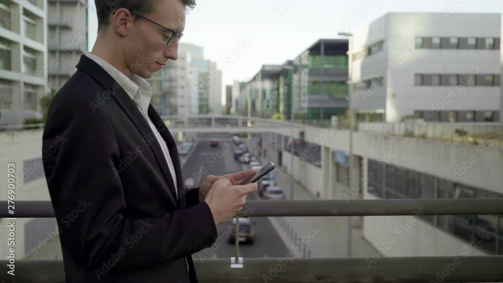 Side view of good looking young Caucasian man walking outside, texting on tablet, swiping. Work, lifestyle concept Side view of good looking young Caucasian man walking outside, texting on tablet, swiping. Work, lifestyle concept