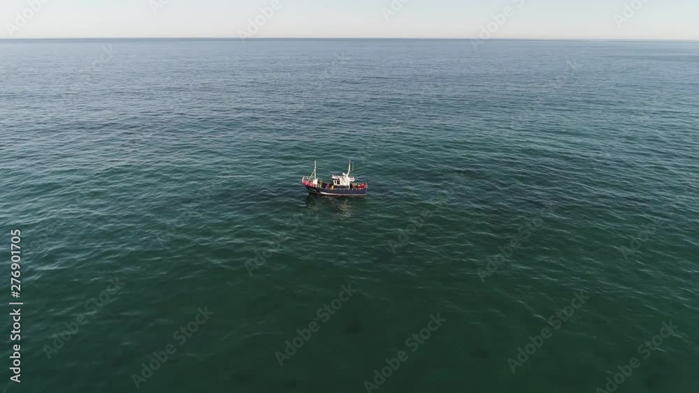 Aerial: Fishing ship close to shore catching fish. Playa de las Catedrales Spain. Aerial: Fishing ship close to shore catching fish. Playa de las Catedrales Spain.