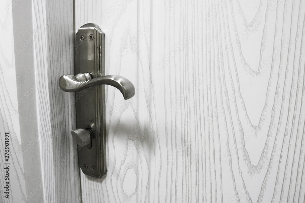 Metallic knob on white horizontal door. Detail of wooden door. Door handle with lock. Furniture accessories. Metallic knob on white horizontal door. Detail of wooden door. Door handle with lock. Furniture accessories.