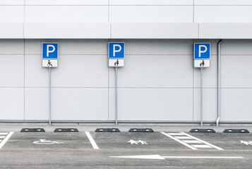 Empty car parking lot at a supermarket with family and disability parking places, public parking road signs 