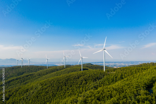 Parco eolico con turbine da 100 metri di diametro per la produzione di energia verde dal vento, su una collina con alberi. Vista aerea con drone. photo