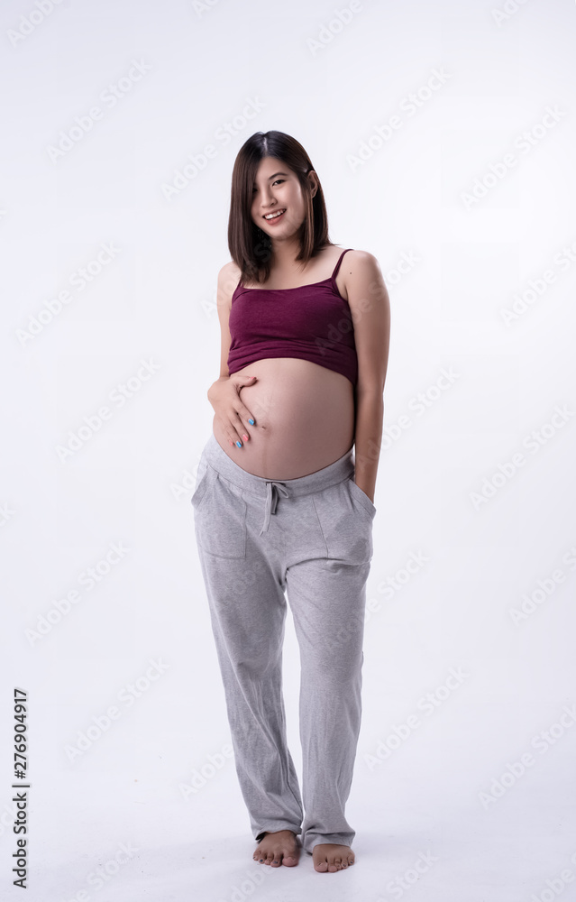 The pregnant woman standing and put hand touching her bellywith love and care,waiting for New born,on white background The pregnant woman standing and put hand touching her bellywith love and care,waiting for New born,on white background
