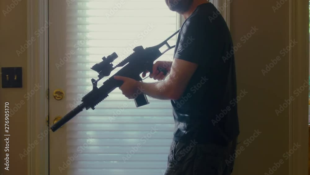 Man nervously walking around house with a rifle