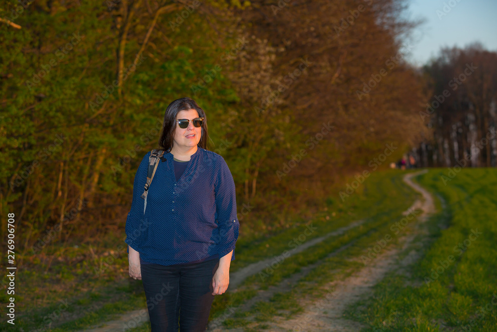 Beautiful lady backpacker enjoys the spring sunset in the field Beautiful lady backpacker enjoys the spring sunset in the field