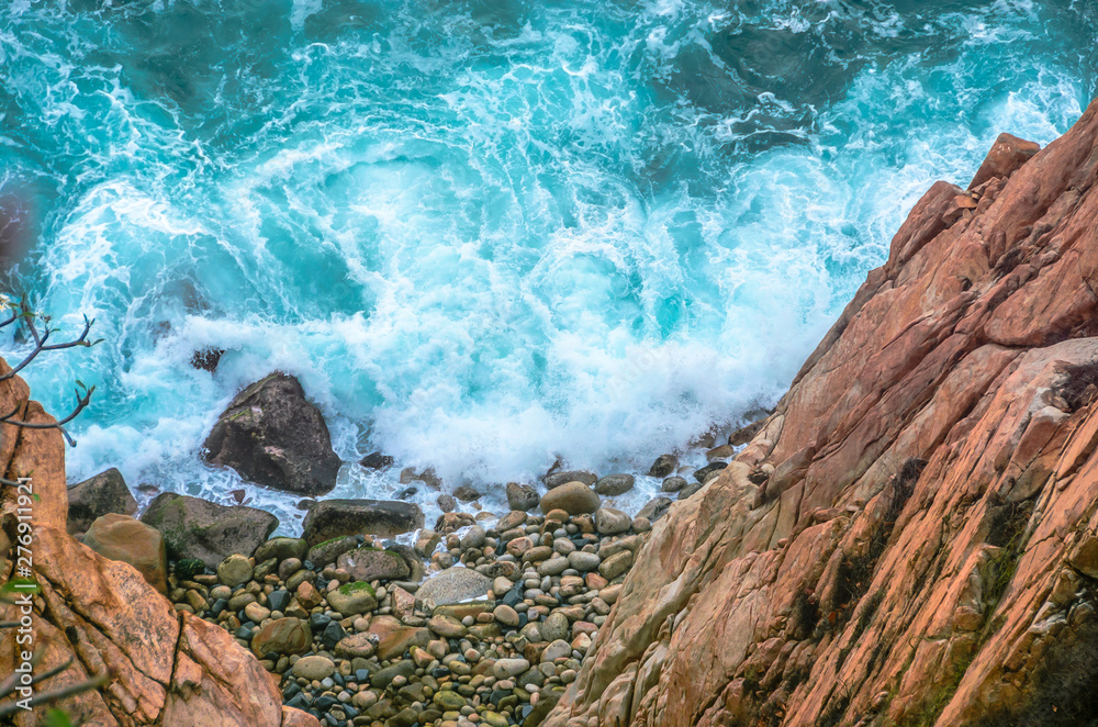 Obraz premium Blue sea with rocky shore in sunny afternoon