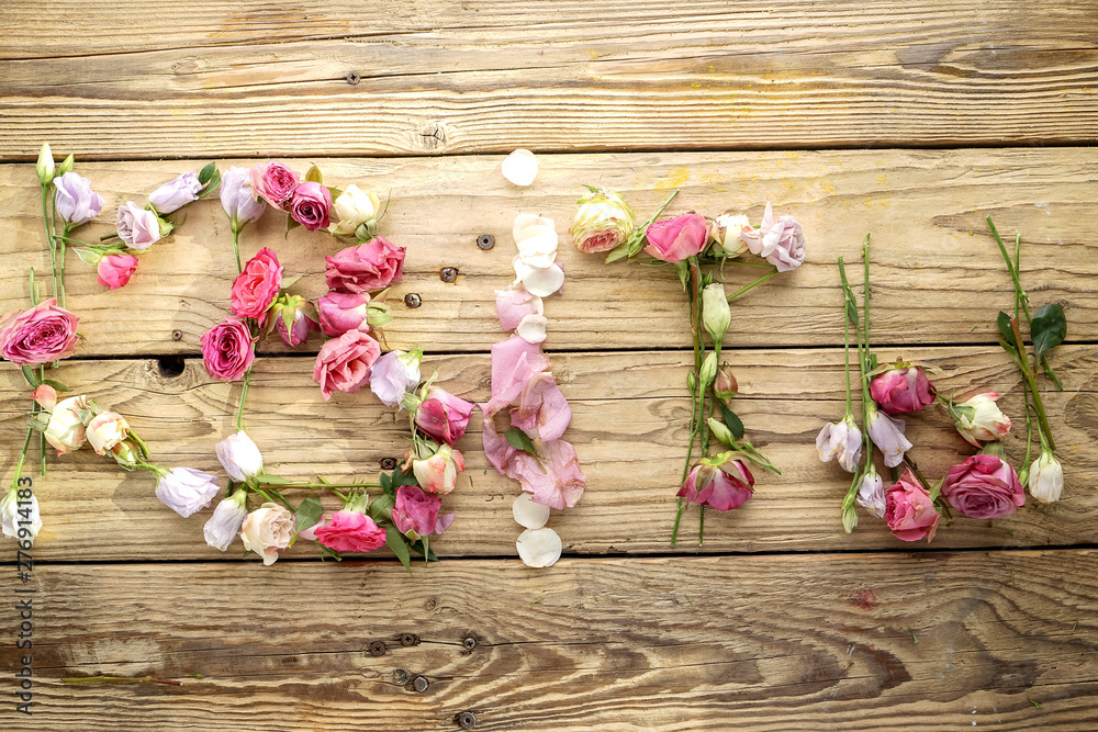 Word Flowers Letters Lined Up With Flowers On An Old Wooden Background Word Flowers Letters Lined Up With Flowers On An Old Wooden Background
