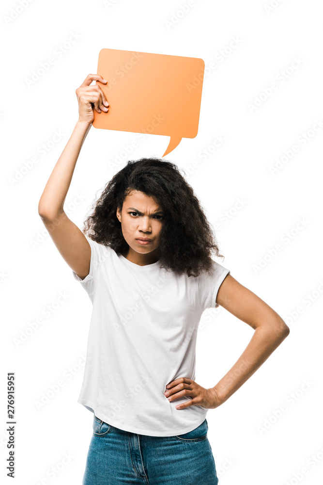 upset african american girl holding orange speech bubble and standing with hand on hip isolated on white upset african american girl holding orange speech bubble and standing with hand on hip isolated on white