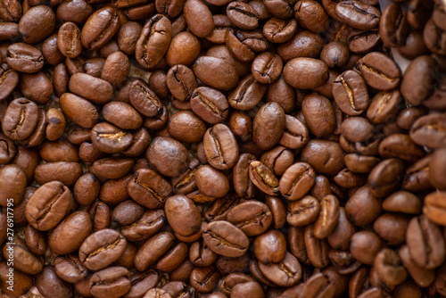 roasted brown coffee beans scattered close-up  background  texture