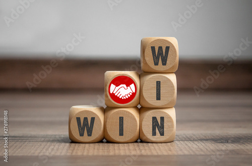 Cubes and dice with handshake icon and win-win-situation on wooden background photo