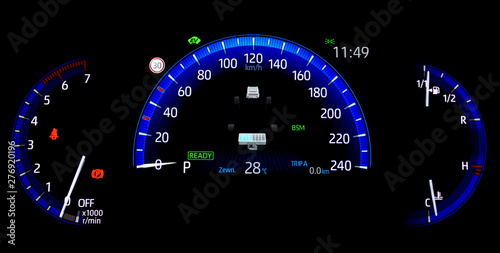 Car counter in hybrid vehicle. Instrument panel with display indicating battery charge level, speedometer, tachometer, odometer, fuel gauge and oil temperature gauge. Blue illuminated display.