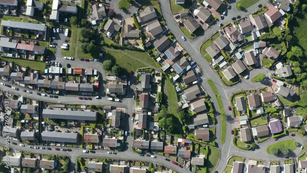Vertical aerial view looking down on small streets and buildings on a small, residential area of a town