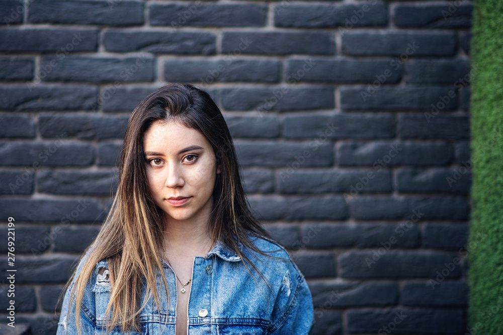 Young caucasian girl with strike hair posing on black brick wall Young caucasian girl with strike hair posing on black brick wall