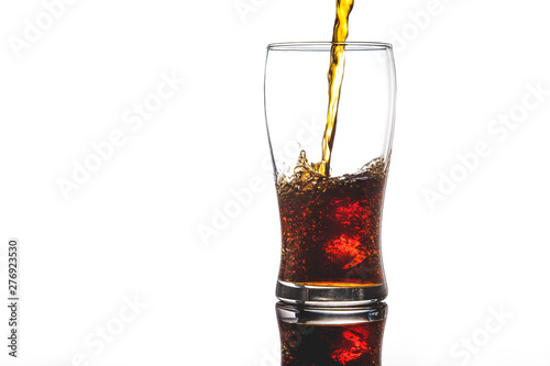 pouring cola into glass with ice on white background Copy space