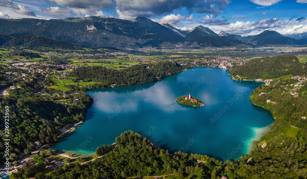 Bled, Slovenia - Aerial panoramic skyline view of Lake Bled (Blejsko Jezero) from high above with the Pilgrimage Church of the Assumption of Maria, Bled Castle and Julian Alps at background at summer - obrazy, fototapety, plakaty 