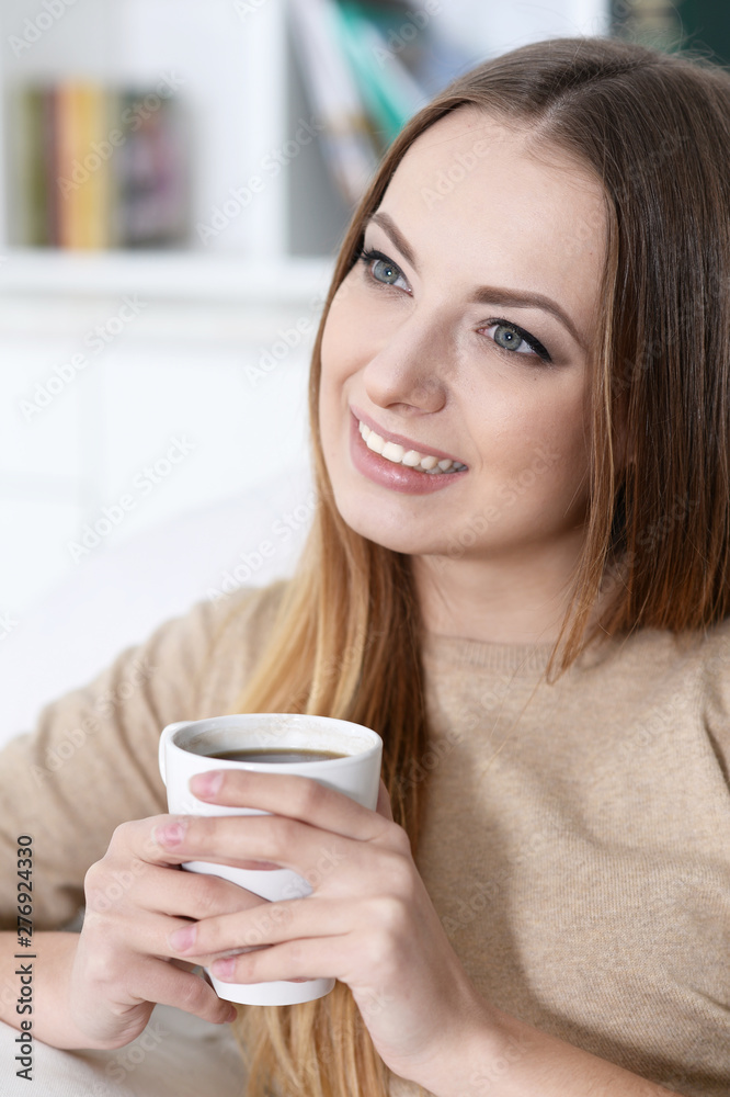 Portrait of young beautiful woman holding white cup Portrait of young beautiful woman holding white cup