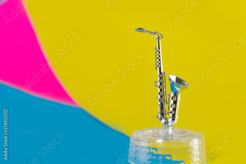 Little golden saxophone isolated on vivid background