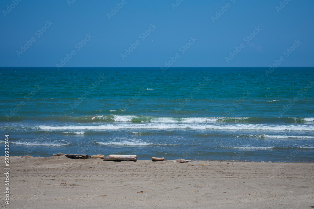 Fototapeta premium Mar azul turquesa en calma, con olas pequeñas y cielo azul despejado, con arena dorada, en las costas de Tecolutla, Veracruz