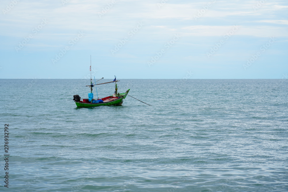 A fisher boat is floating on the sea alone before sunset. A fisher boat is floating on the sea alone before sunset.