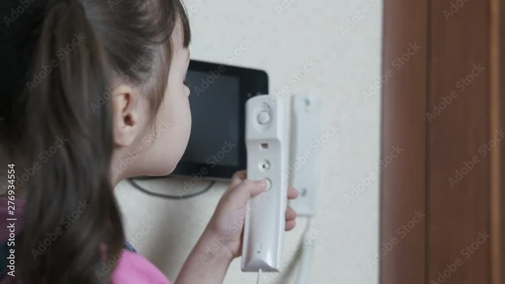 The child is in danger. A little girl without parental supervision talks on the intercom and presses the buttons. The child is in danger. A little girl without parental supervision talks on the intercom and presses the buttons.