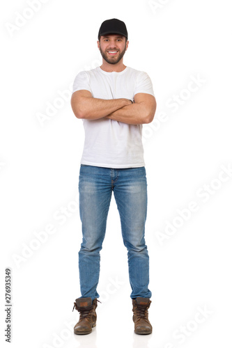 Confident And Happy Young Man Is Standing With Arms Crossed photo