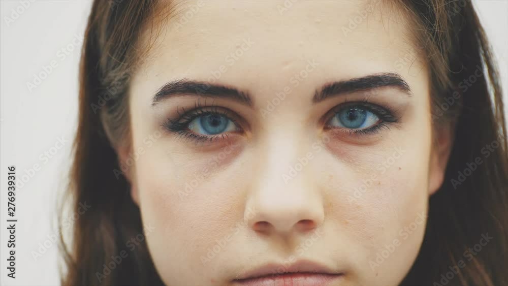 Face of lovely young female looking down then looking at the camera with big blue eyes and looking down again. Face of lovely young female looking down then looking at the camera with big blue eyes and looking down again.