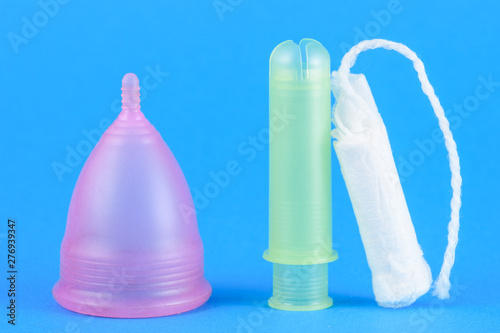 intimate tampon and menstrual cup in blue background