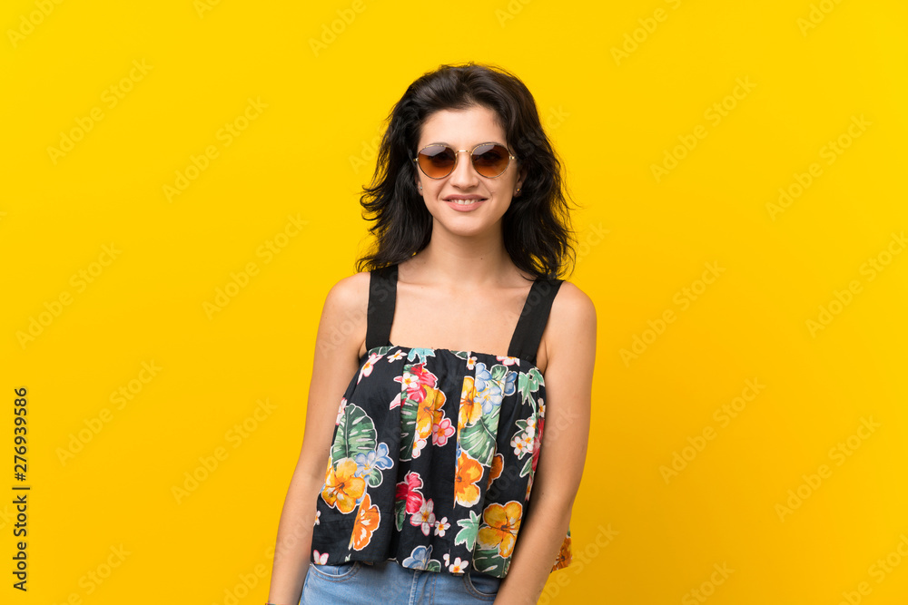 Young woman over isolated yellow background with glasses Young woman over isolated yellow background with glasses