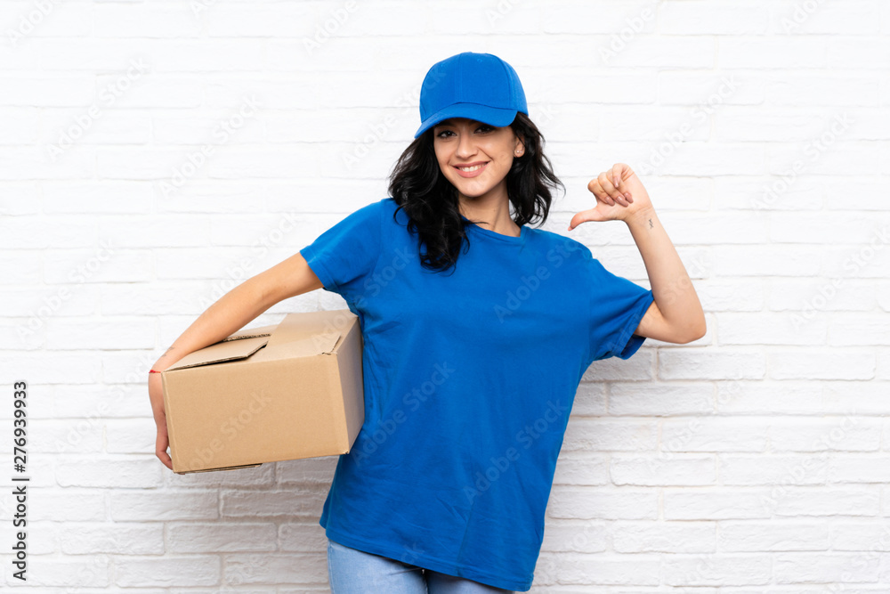 Young delivery woman over white brick wall proud and self-satisfied Young delivery woman over white brick wall proud and self-satisfied