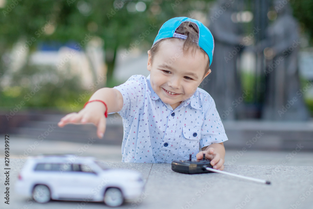 The boy is controling the toy car with a remote control. child's face with bright emotions close-up The boy is controling the toy car with a remote control. child's face with bright emotions close-up