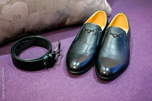 black belt and black shoes on the purple sofa