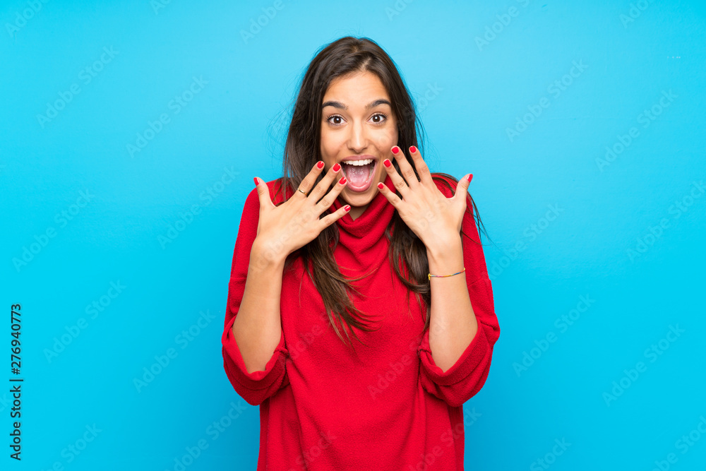 Young woman with red sweater over isolated blue background with surprise facial expression Young woman with red sweater over isolated blue background with surprise facial expression