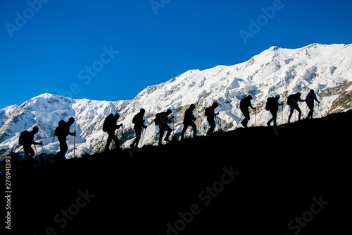 people on the background of the glacier go uphill