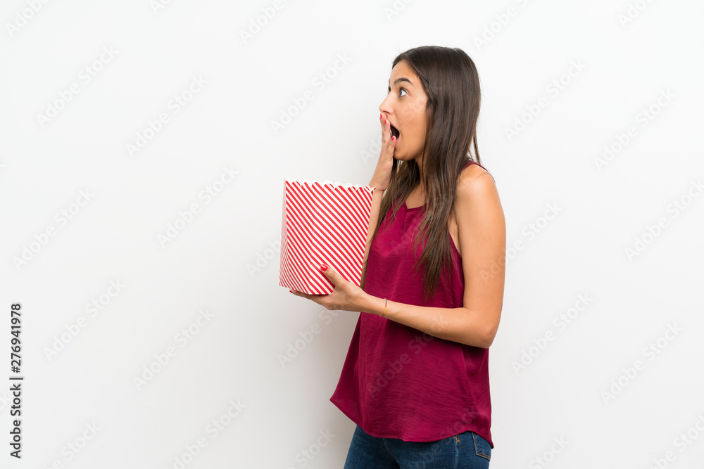 Young woman over isolated white background holding a bowl of popcorns Young woman over isolated white background holding a bowl of popcorns